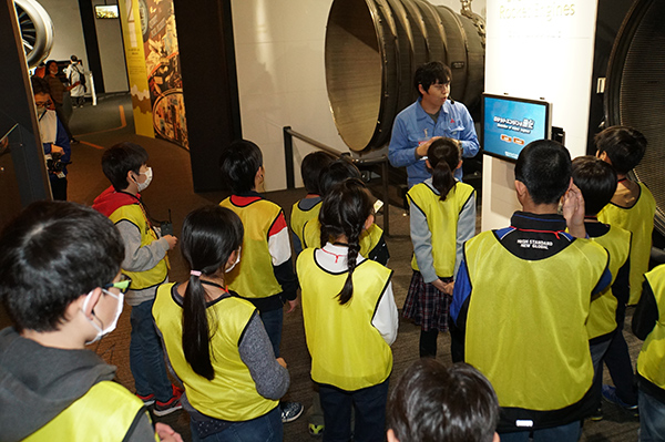 <div class="comClm3"> <div class="inC2"> <div class="inClmPosi">  <p>On February 8, MHI Group invited 55 local fourth, fifth and sixth graders to attend the "Minatomirai Aerospace Classroom" at Mitsubishi Minatomirai Industrial Museum in Yokohama. To begin, the students watched a film on the museum's giant screen describing the "life" of a launch vehicle, from its manufacture through to the end of its designated mission. Next, the young participants were guided through the museum's various exhibits relating
