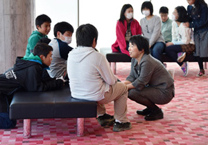A volunteer greeting youngsters from Iwaki