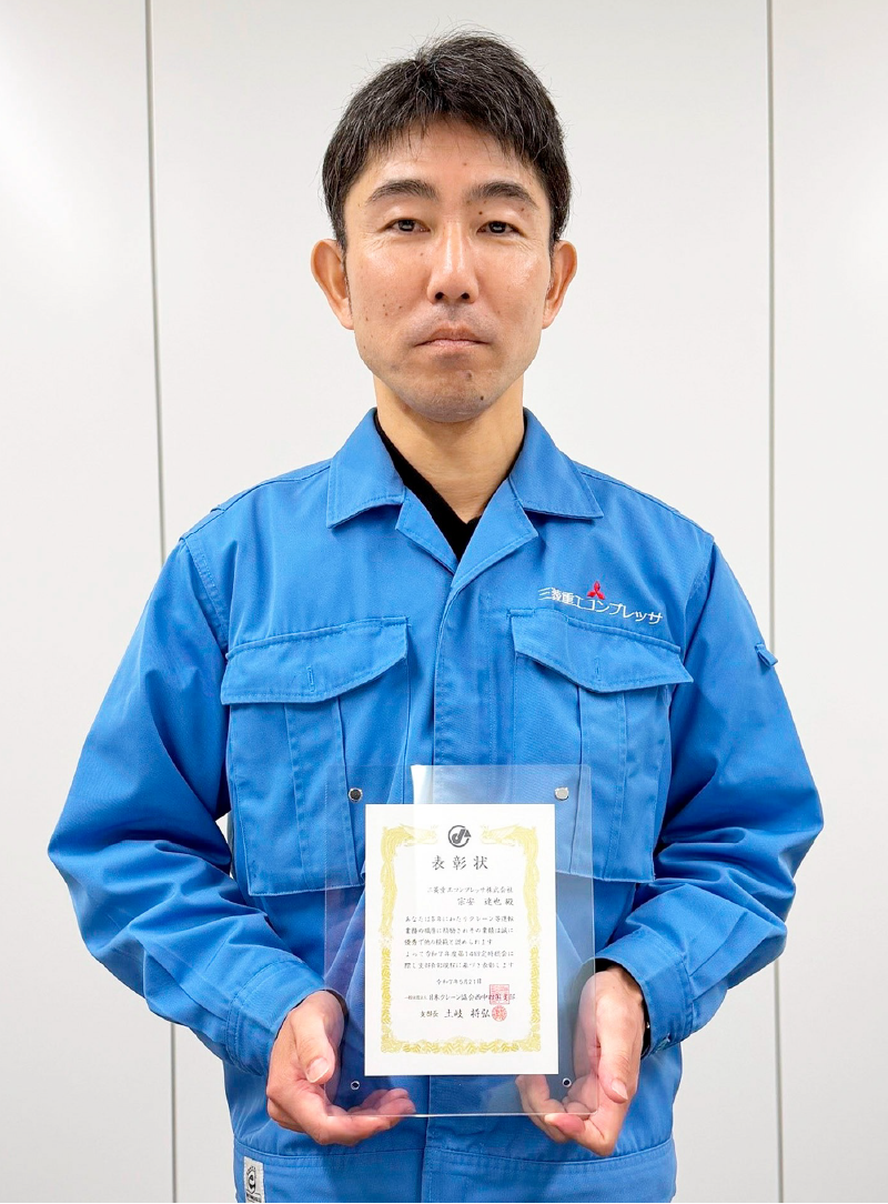 Mr. Muneyasu holding the certificate for FY2025 Award for Excellent and Exemplary Crane Operators