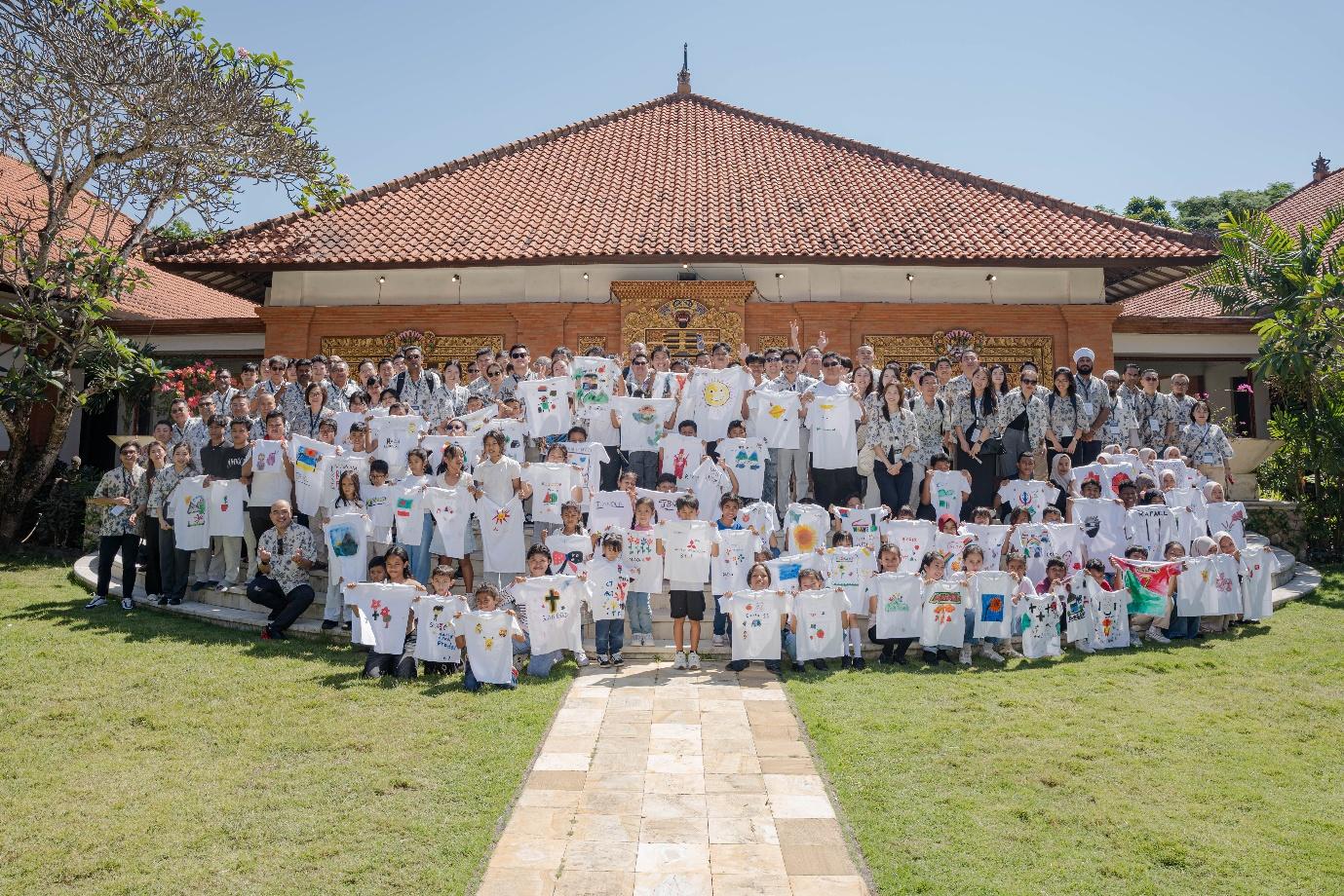 Delegates and children holding painted T-shirts during the CSR session at Museum Pasifika