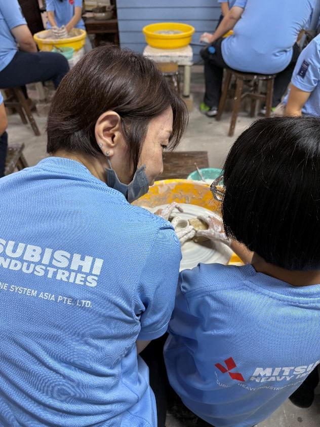 MHI-ESA volunteers supporting a participant during a guided pottery activity