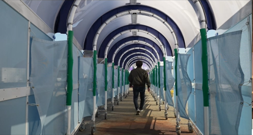 『ボーディング・アーケード』通路の内側を通行する写真(名古屋空港にて)