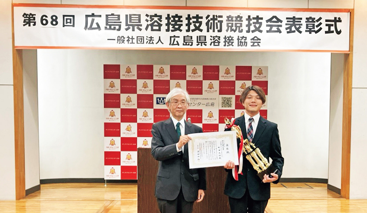 表彰状とトロフィーを授与される町田さん