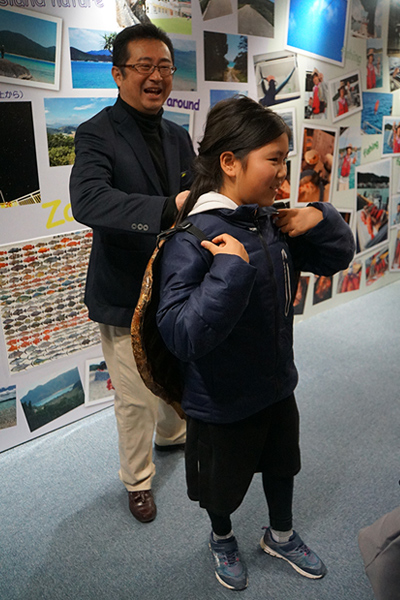 Trying on a loggerhead sea turtle shell (standing: Mr. Matsuzawa)