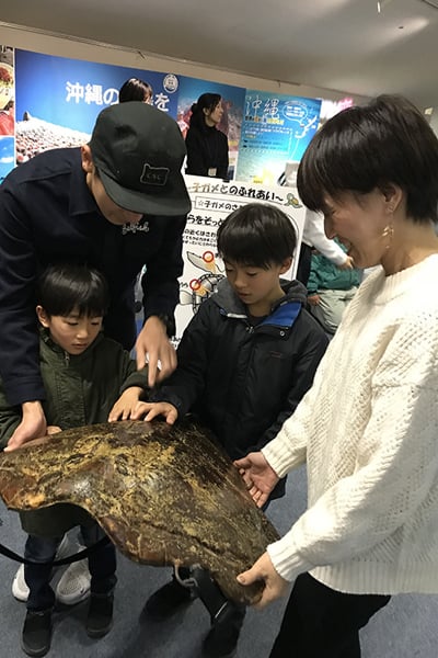 Young participants touching a sea turtle shell for the first time