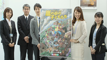 Yu Kobayashi and Akari Sorada present the 'Children of the Storm' publicity board.