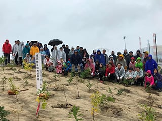 写真：雨の中、大勢が協力して植樹しました