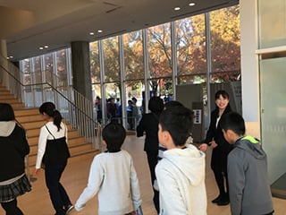 A family member ushering students in Mihara