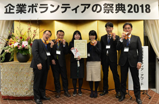 写真：企業ボランティアアワード表彰式に出席した社員とNPO代表