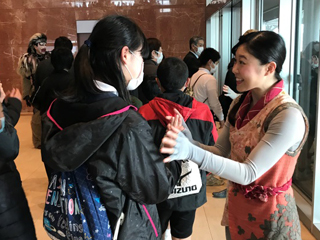 An actor greeting students after a performance