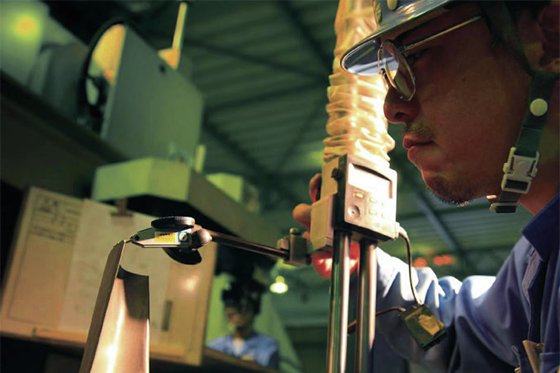 Photo:One by one, with painstaking care, a worker using a specialized tool verifies the flawless machining of countless blade surface cooling holes created on the turbine blade via electro spark machining.