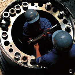 Photo:An operation to assemble a rotor is underway, which will take three days and nights and involve using a total of twelve bolts to join large ring-shaped parts tightened to an incredible 600MPa pressure (approx. 4,500 tons in force). Takasago Machinery Works, Hyogo Prefecture.