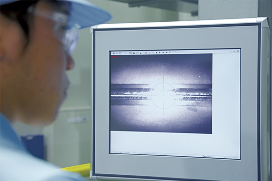 Photo:The bowl-shape cell components that form the superconducting accelerating cavity are precisely welded in a high-precision electron beam welding device, while being monitored on a display screen.